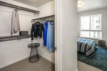 A closet in a bedroom with a bed and a window
